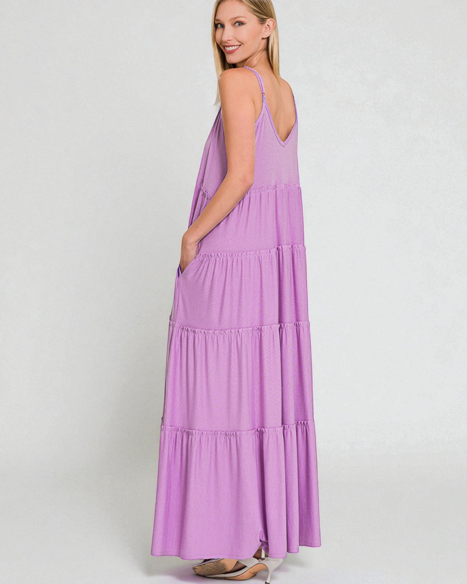 Woman wearing a purple tiered dress on a white background