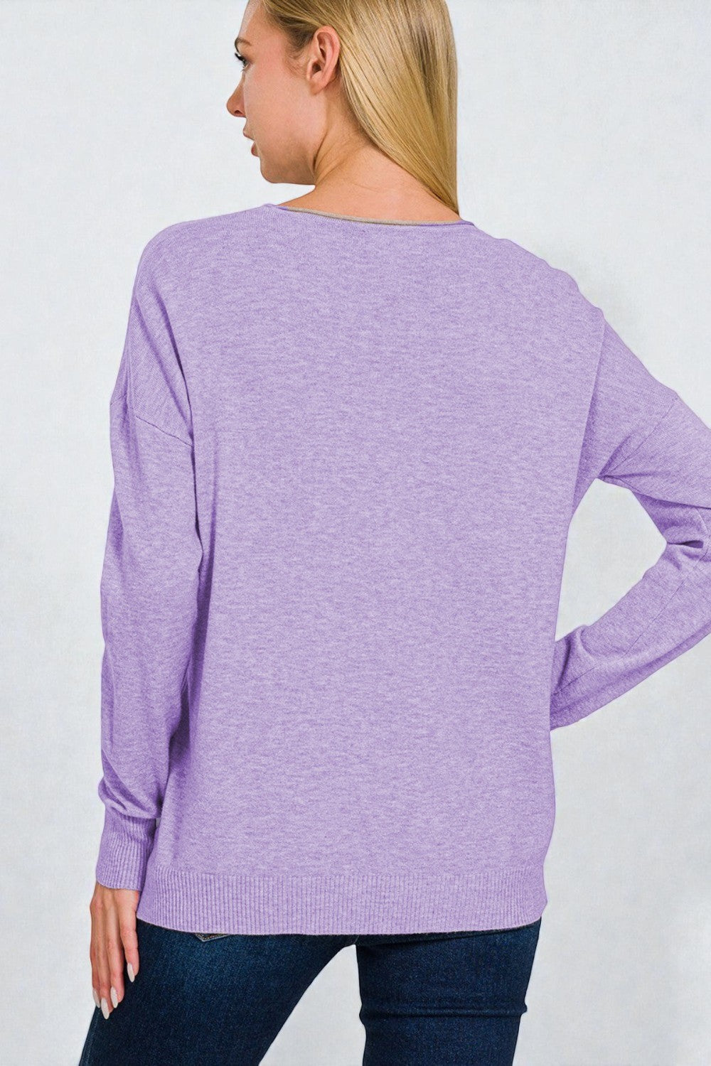 Person wearing a purple sweater on a plain background