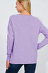 Person wearing a purple sweater on a plain background