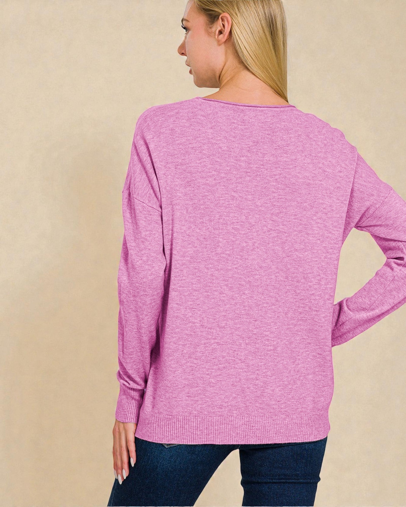 Woman wearing a pink sweater against a beige background