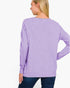 A woman shown from the back wearing a lavender heather long-sleeve knit top and dark blue jeans against a plain white background.