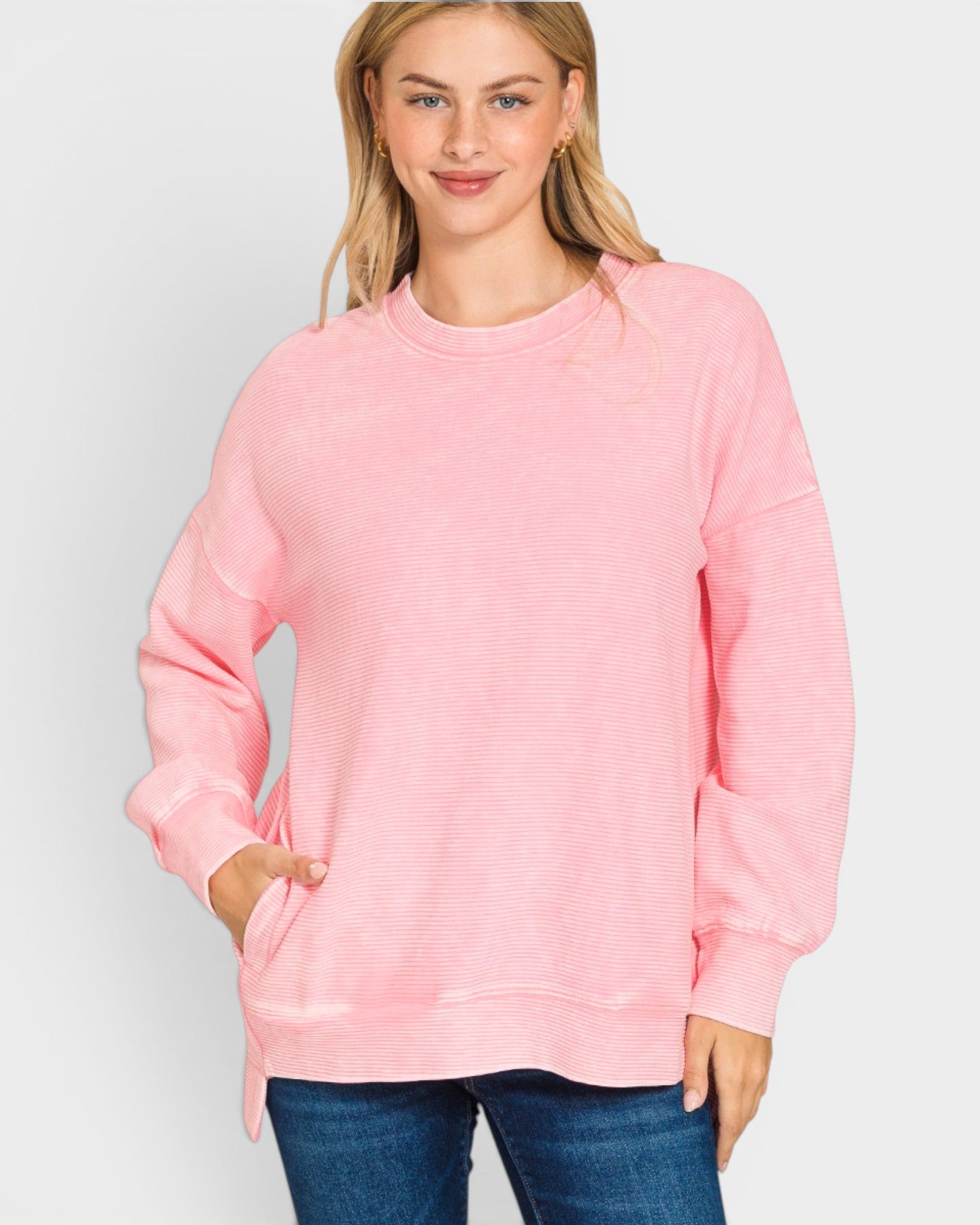 Person wearing a pink sweatshirt on a plain background
