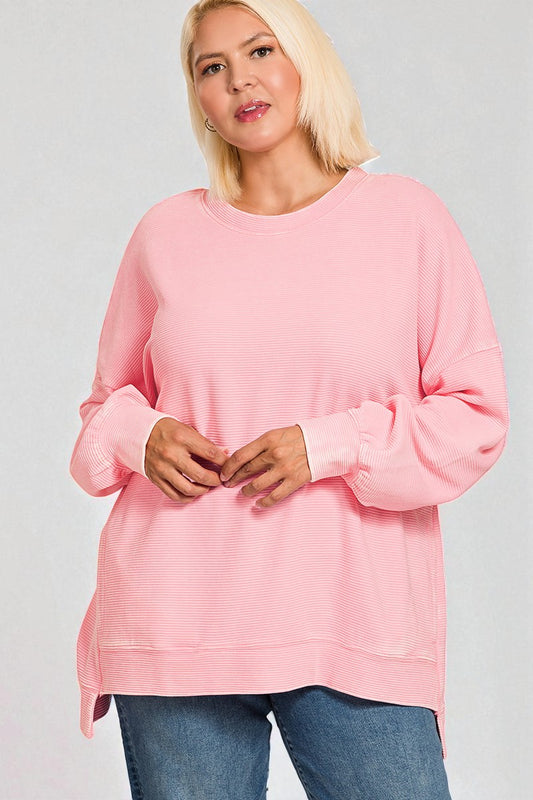 Woman wearing a pink sweatshirt against a plain background