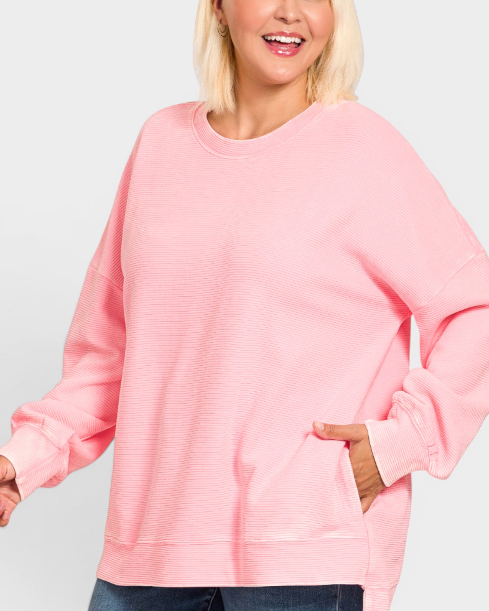 Person wearing a pink sweatshirt against a plain background