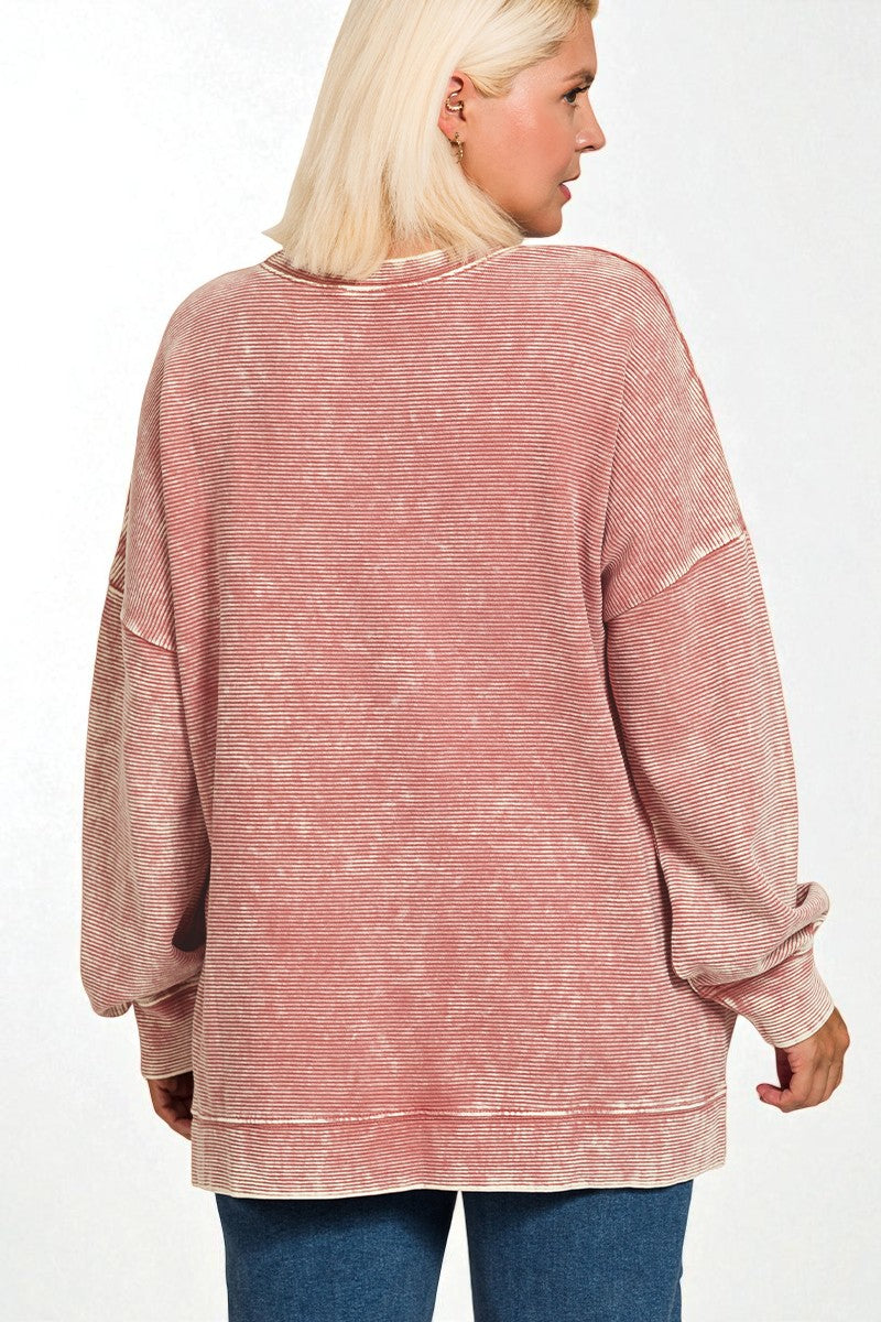 Person wearing a pink ribbed sweater on a white background