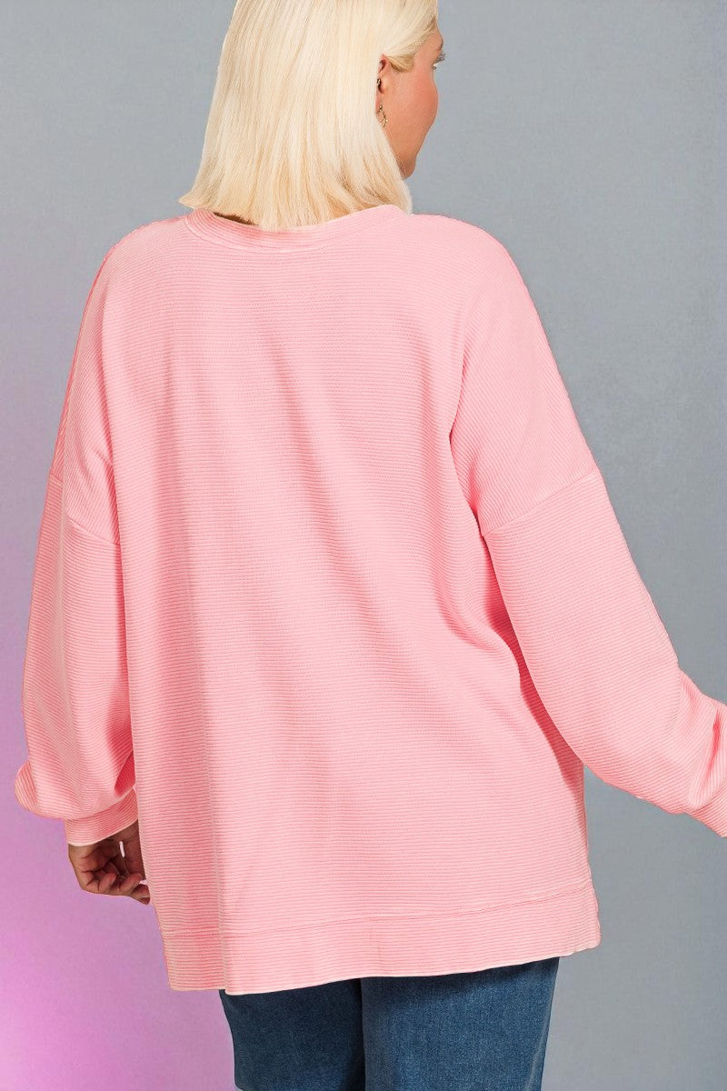 Person wearing a pink sweater with a gray background