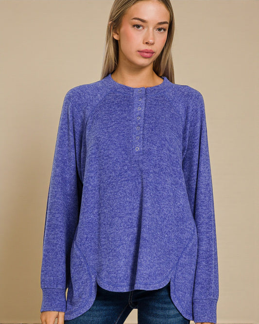 Woman wearing a blue long-sleeve shirt against a beige background