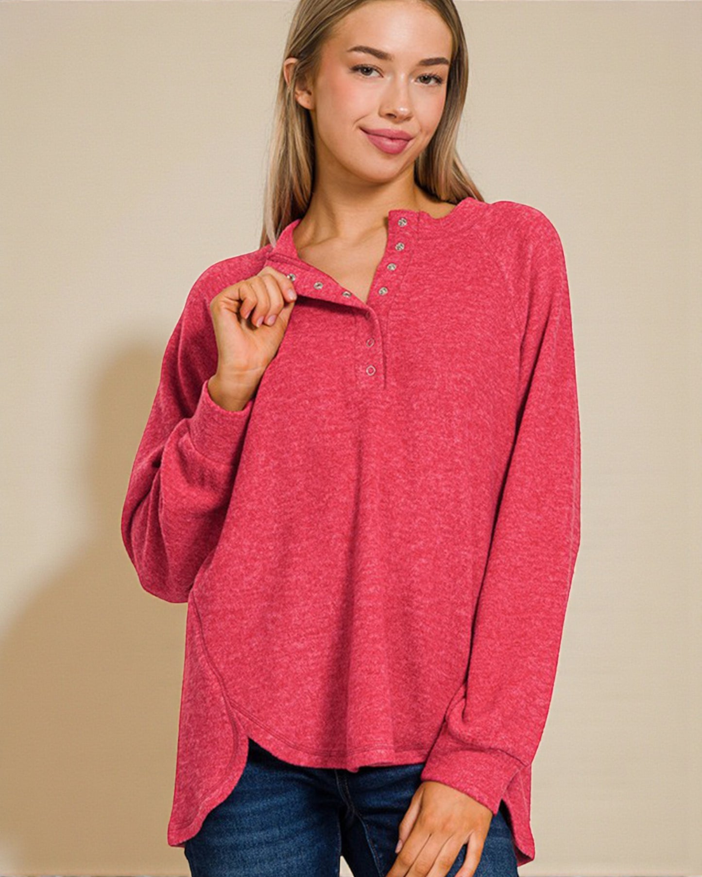 Woman wearing a red long-sleeve shirt against a beige background