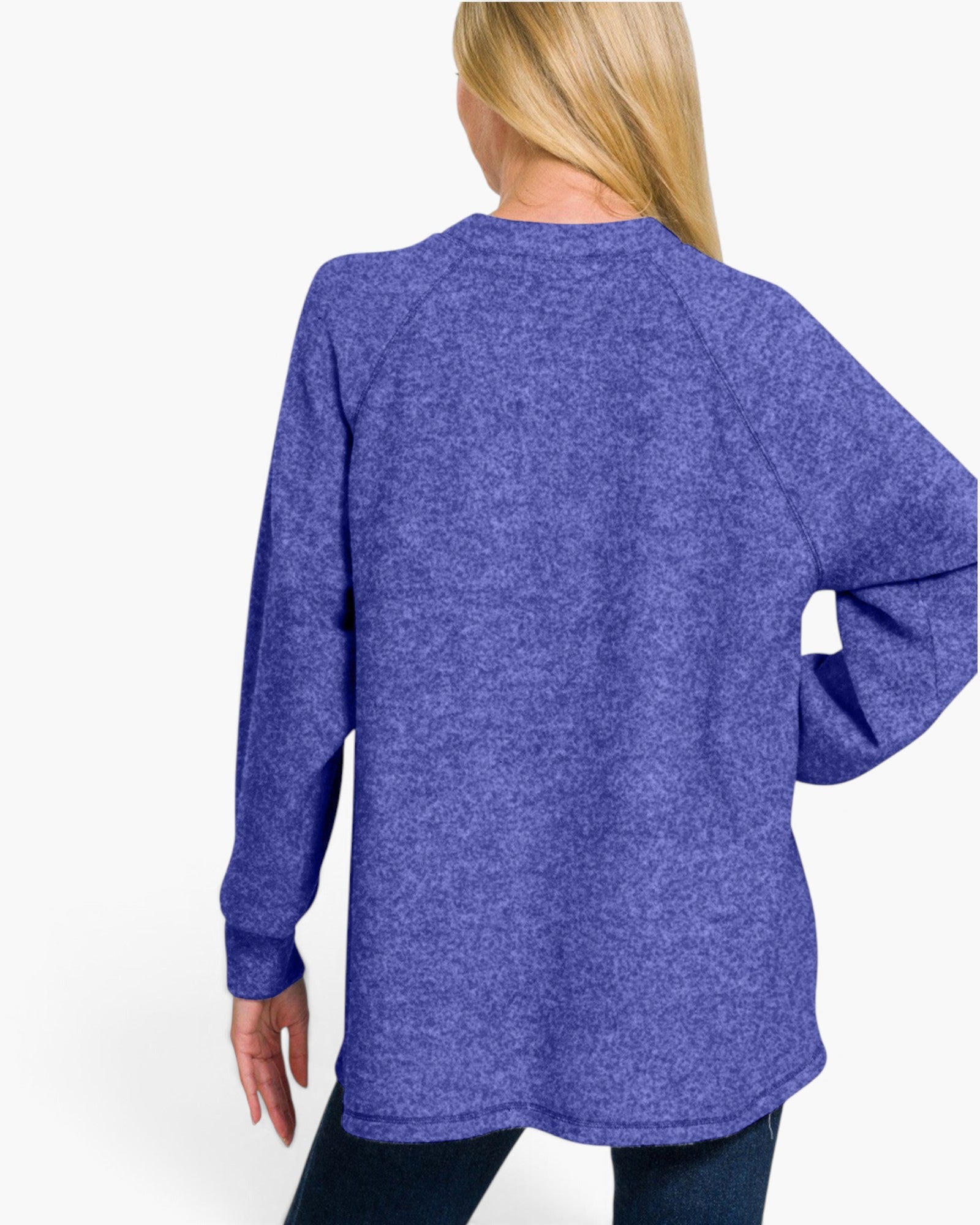 A woman shown from the back wearing a heathered purple long-sleeve raglan sweatshirt and dark jeans against a plain white studio background.