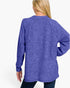 A woman shown from the back wearing a heathered purple long-sleeve raglan sweatshirt and dark jeans against a plain white studio background.