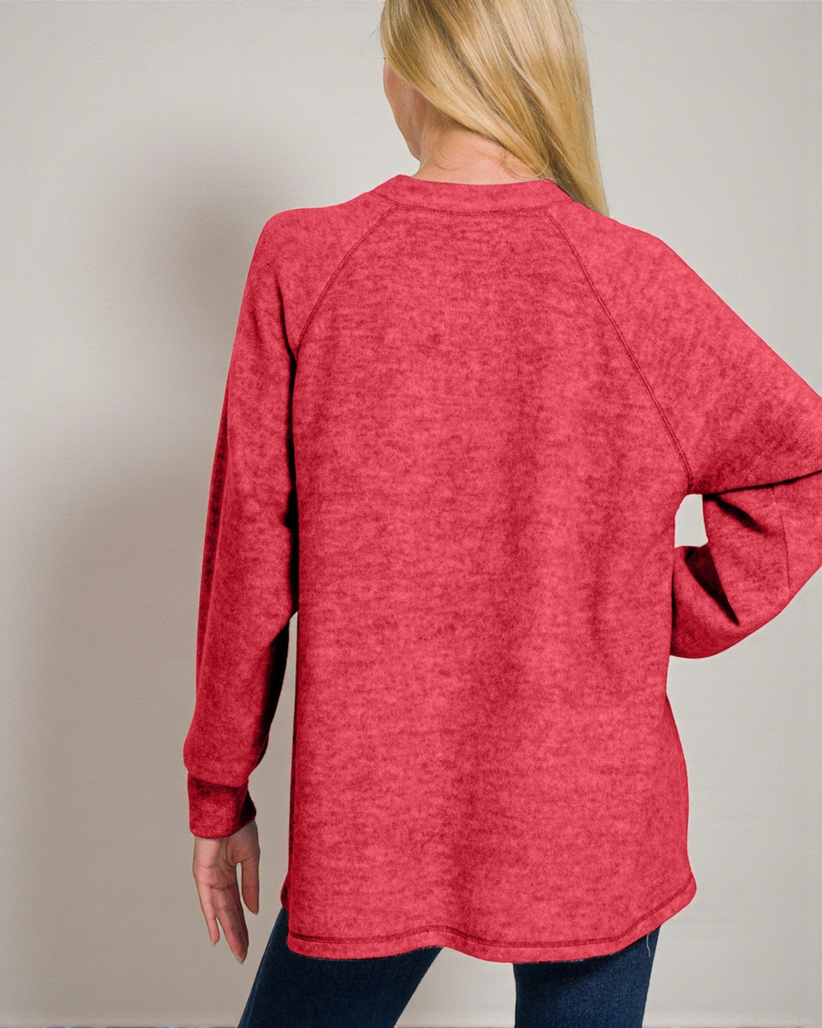 Person wearing a red long-sleeve shirt against a plain background