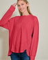Woman wearing a red long-sleeve shirt against a plain background