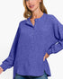 A woman wearing a heathered periwinkle blue long-sleeve henley top with a buttoned collar, shown against a plain white background.