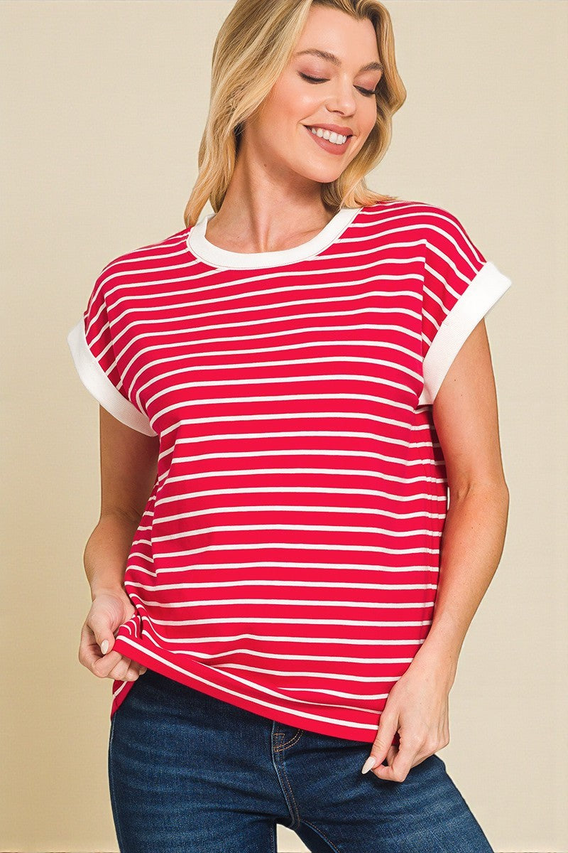 Woman wearing a red and white striped shirt with blue jeans on a beige background