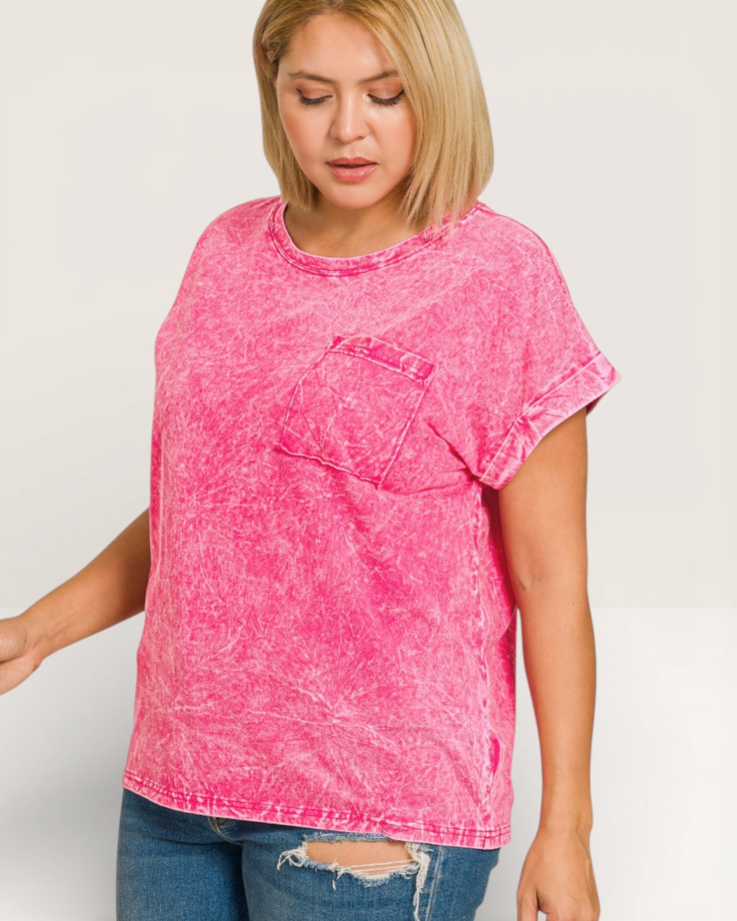 Woman wearing a pink acid-wash t-shirt on a white background