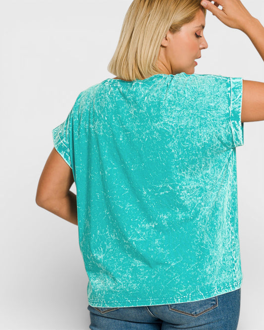 Woman wearing a turquoise sleeveless top against a white background