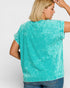 Woman wearing a turquoise sleeveless top against a white background