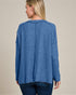 Woman wearing a blue sweater against a beige background