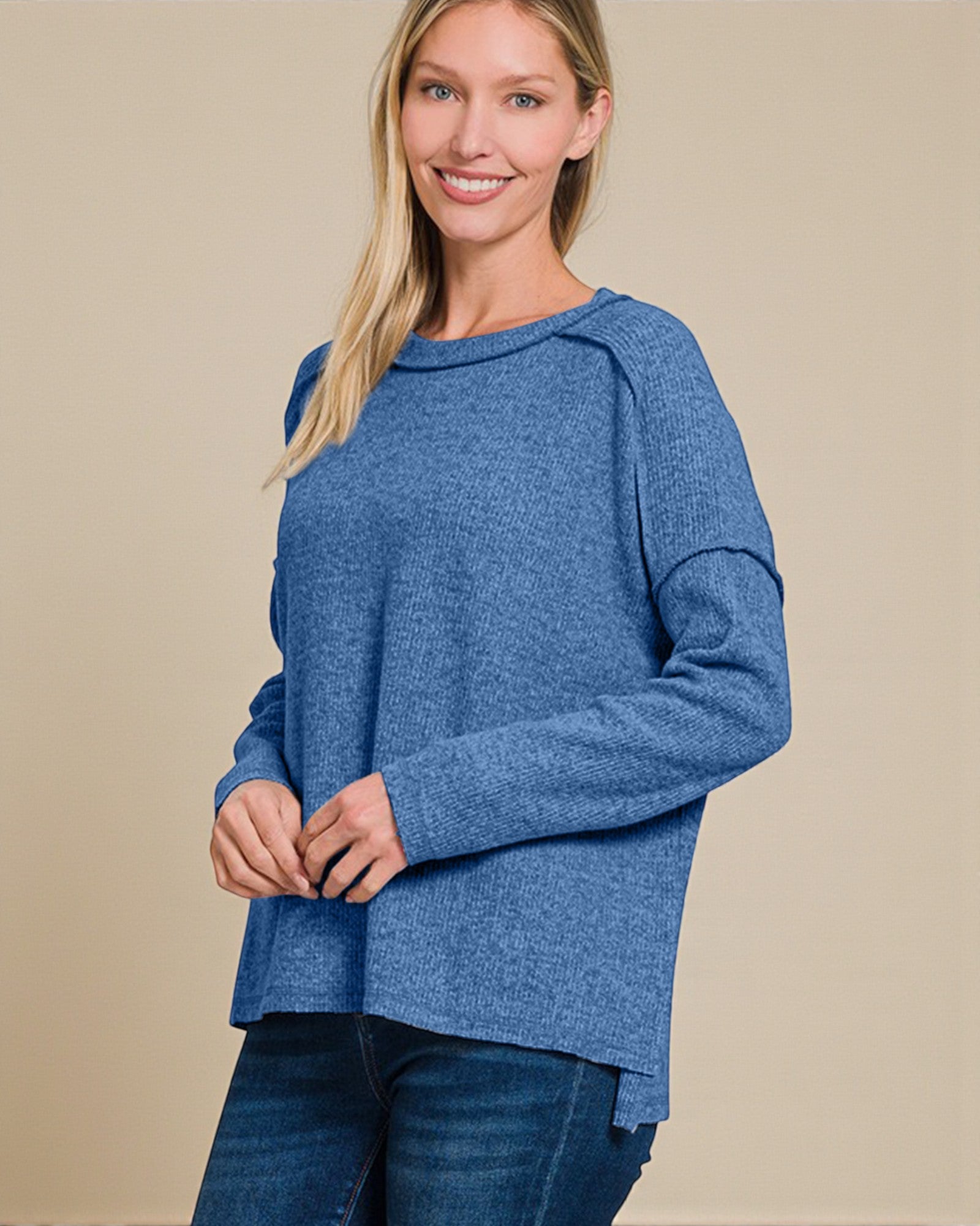 Woman wearing a blue sweater against a beige background