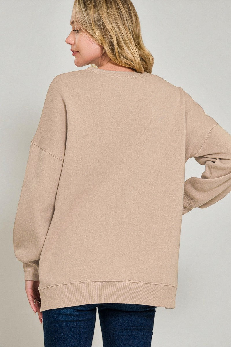 Woman wearing a beige sweater against a plain background