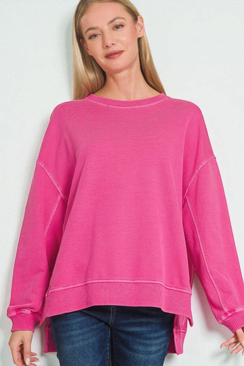 Woman wearing a bright pink sweatshirt against a white background