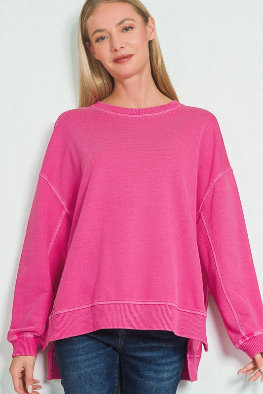 Woman wearing a bright pink sweatshirt against a white background