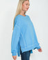 Woman wearing a light blue sweatshirt on a white background