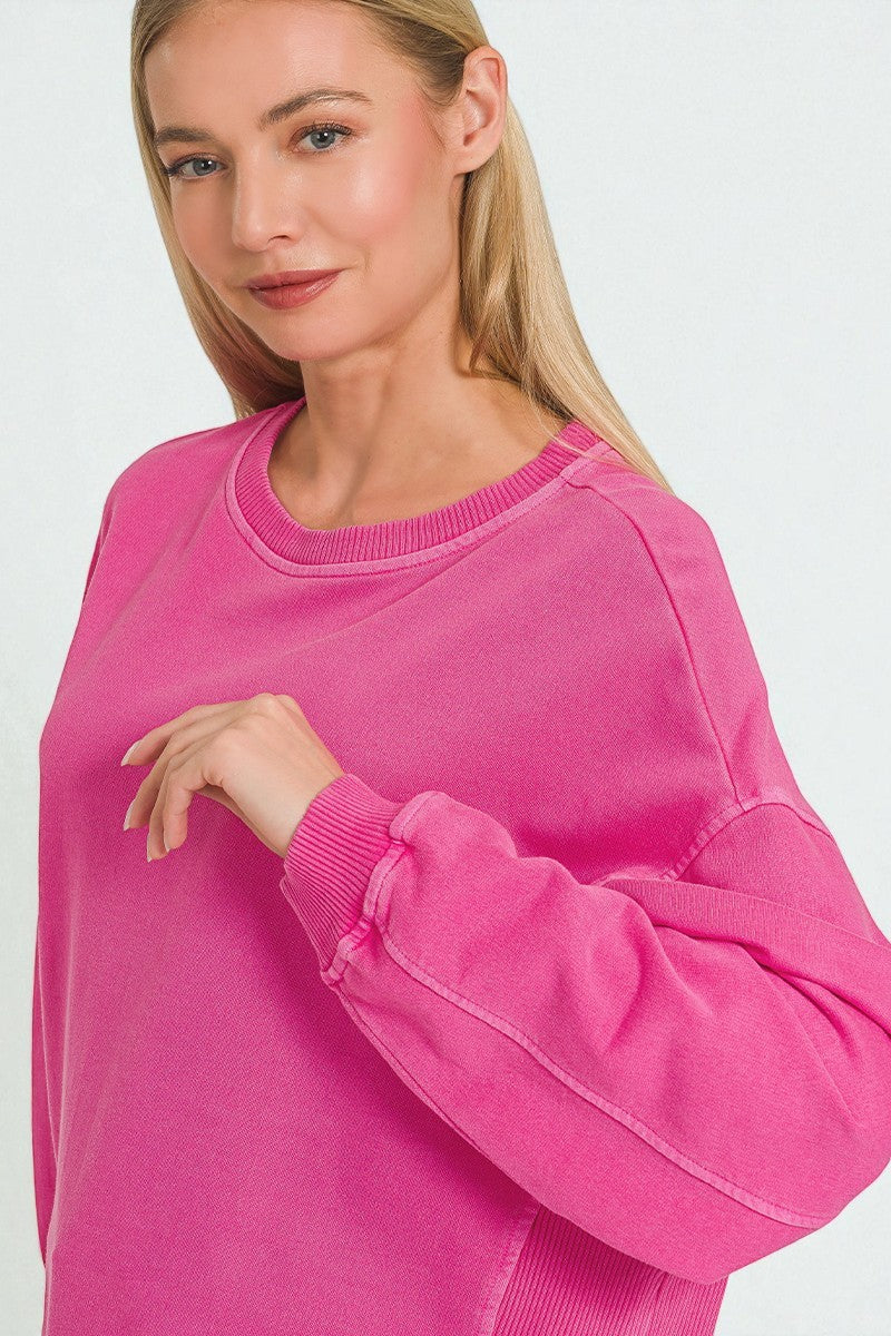 Woman wearing a bright pink sweatshirt on a white background