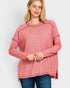 Woman wearing a pink long-sleeve top on a white background