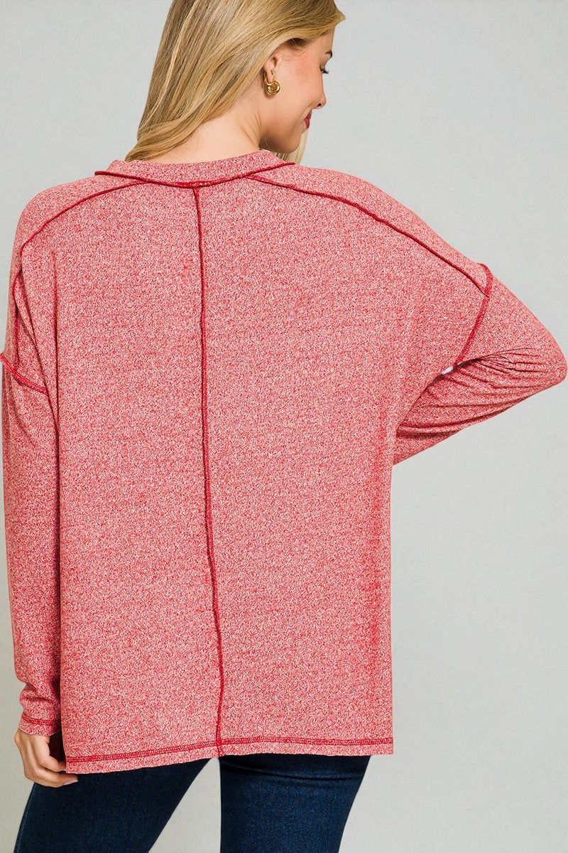 Person wearing a red top with a plain background