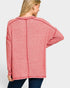 Woman wearing a pink cardigan on a white background