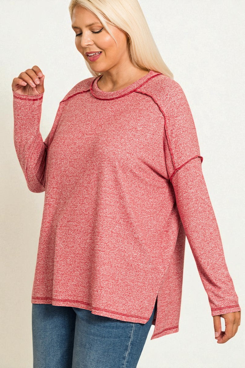 Woman wearing a pink long-sleeve top and blue jeans on a white background