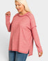 Woman wearing a pink long-sleeve top on a white background