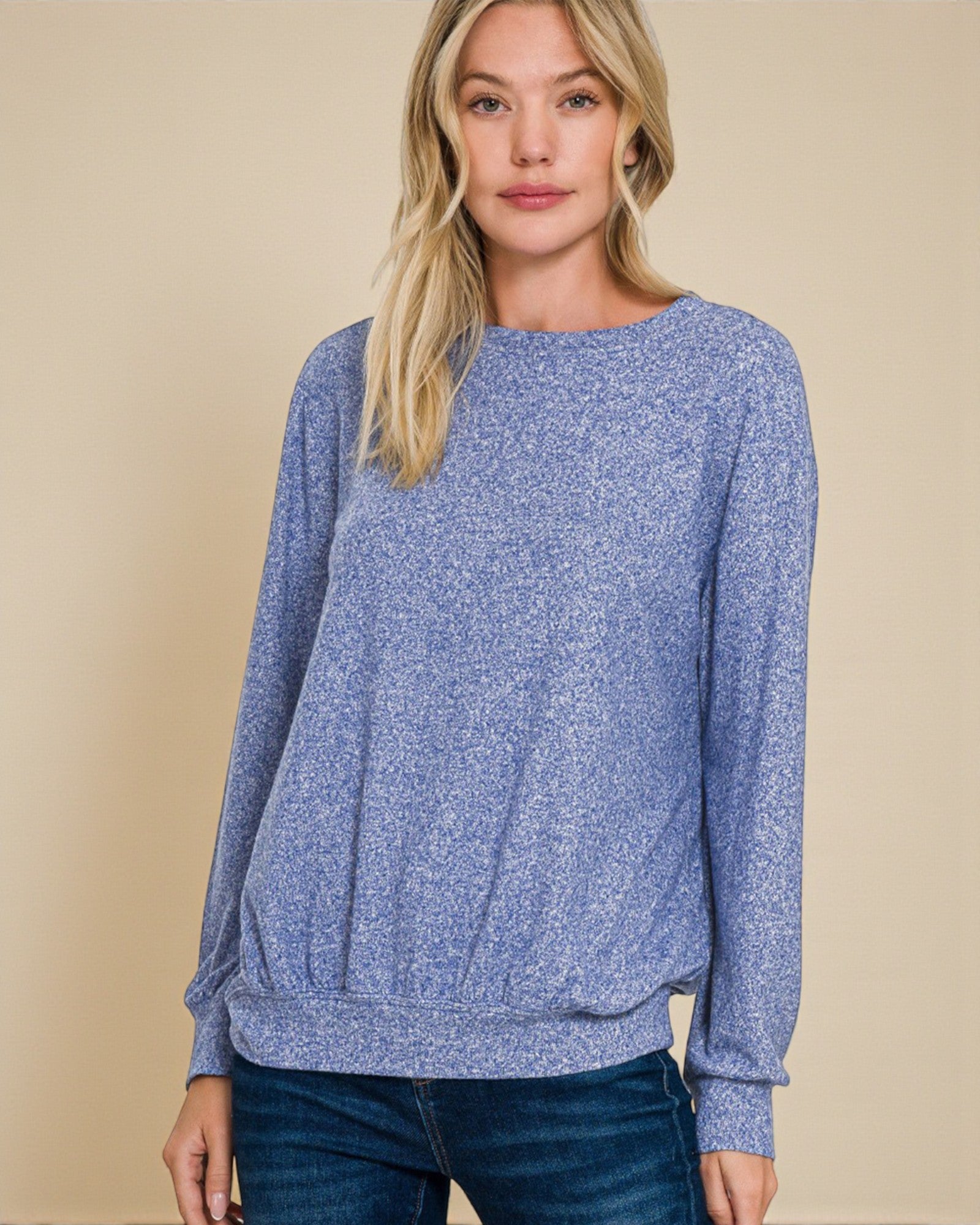 Woman wearing a blue sweater against a beige background