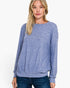 A woman wearing a long-sleeve crewneck sweater in a heathered periwinkle blue color, paired with dark blue jeans, against a plain white background.