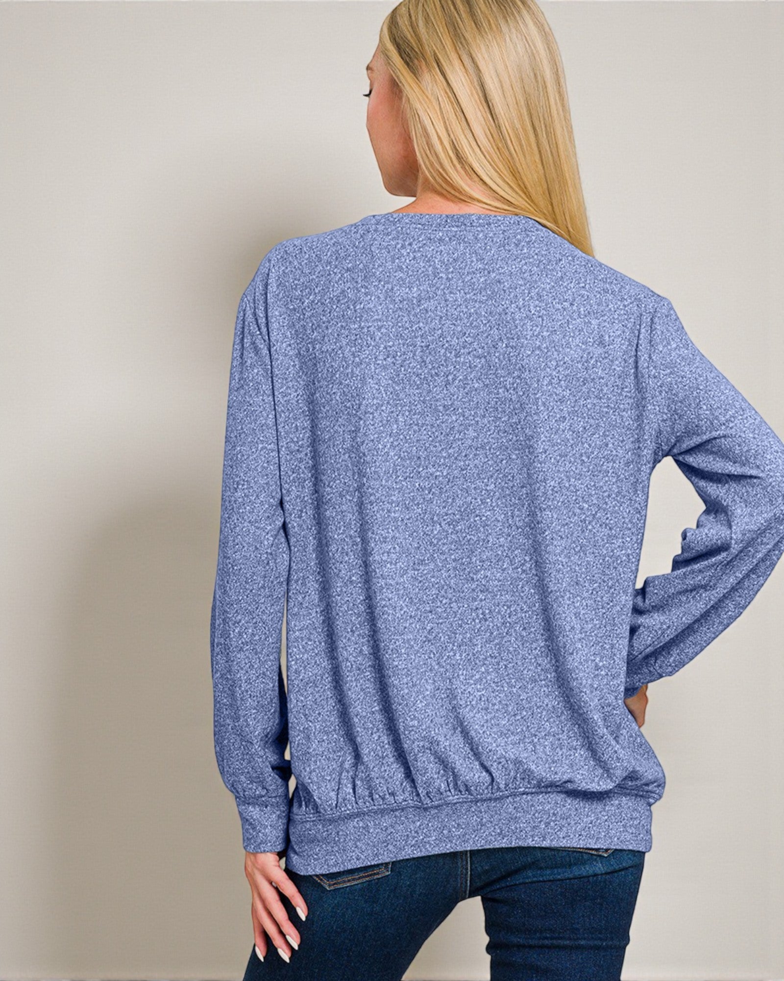 Person wearing a blue sweater with a plain background