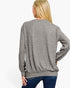 A woman shown from the back wearing a heather gray long-sleeve crewneck sweatshirt and blue jeans against a plain white studio background.