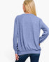 A woman shown from the back wearing a heathered blue long-sleeve crewneck sweatshirt and dark blue jeans against a plain white background.