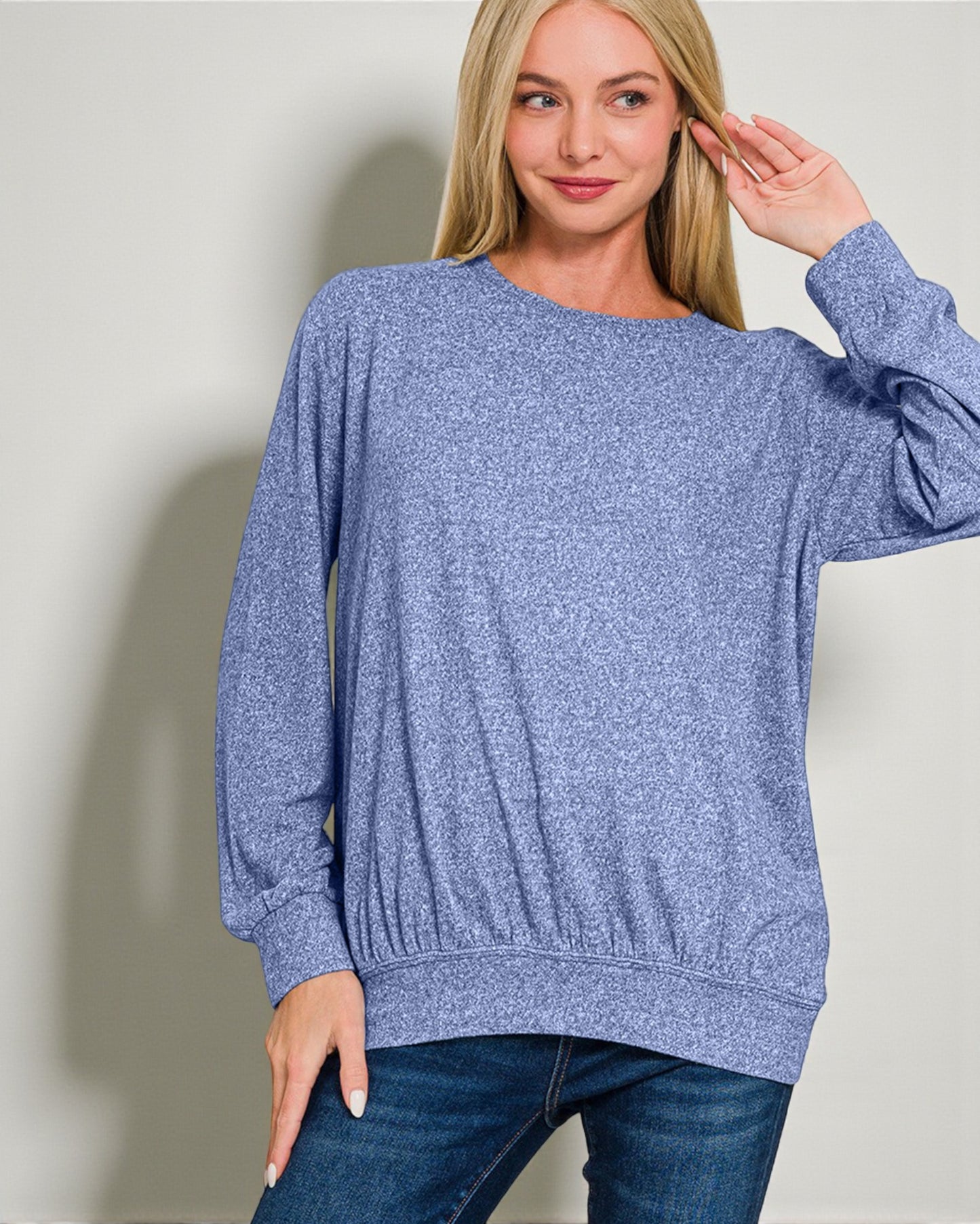 Woman wearing a blue sweater against a plain background