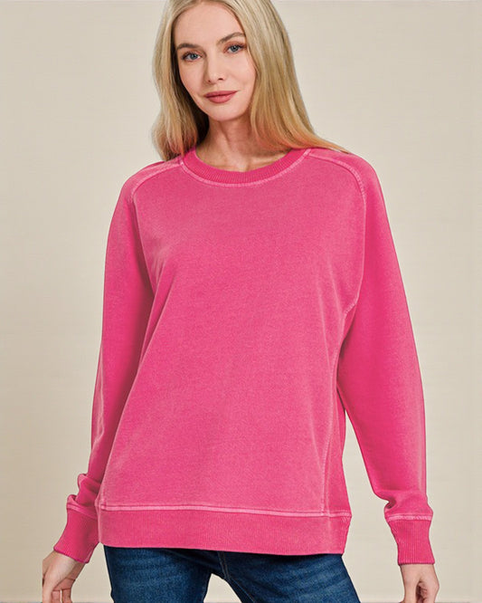 Woman wearing a pink sweatshirt against a beige background