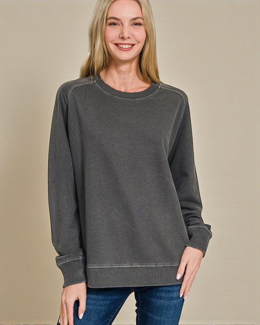 Woman wearing a gray sweatshirt against a beige background