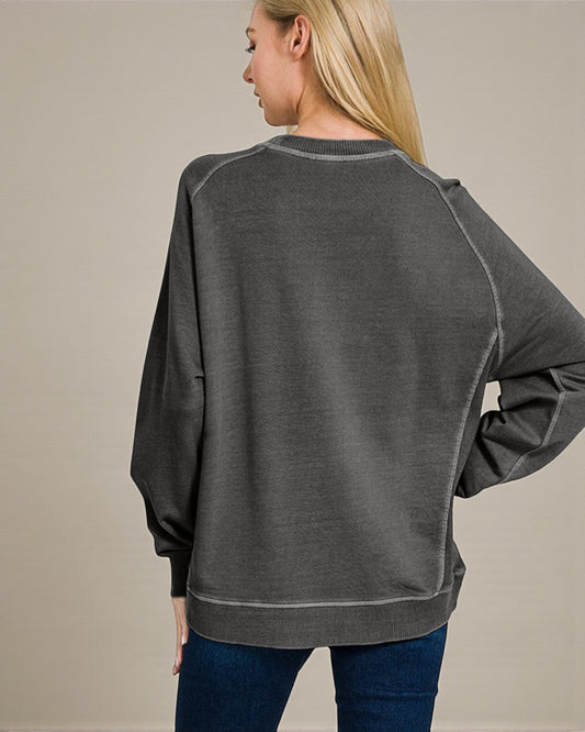 Person wearing a gray sweatshirt with a neutral background