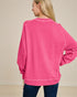 Person wearing a pink sweatshirt on a beige background