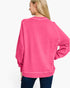 A woman wearing a bright pink long-sleeve sweatshirt, shown from the back against a plain white background.