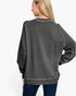 A woman shown from the back wearing a dark gray heathered crewneck sweatshirt with contrast stitching and long raglan sleeves, paired with blue jeans, against a plain white background.