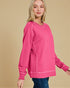 Woman wearing a pink sweatshirt against a beige background