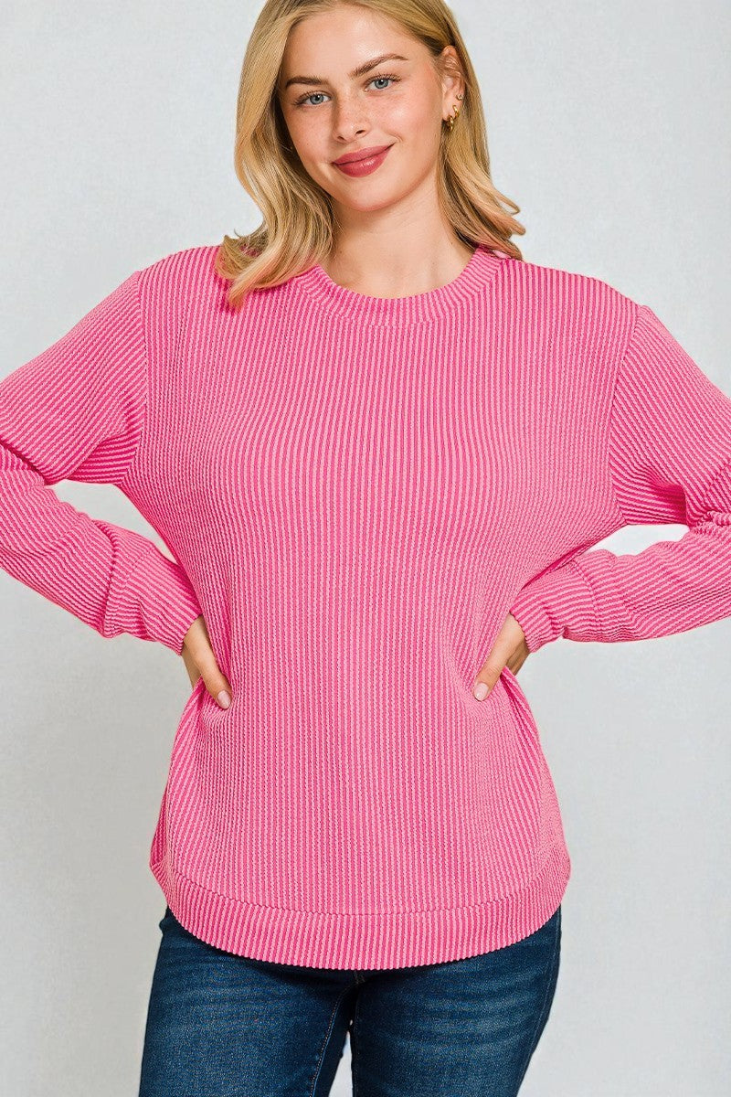 Woman wearing a pink sweater against a plain background