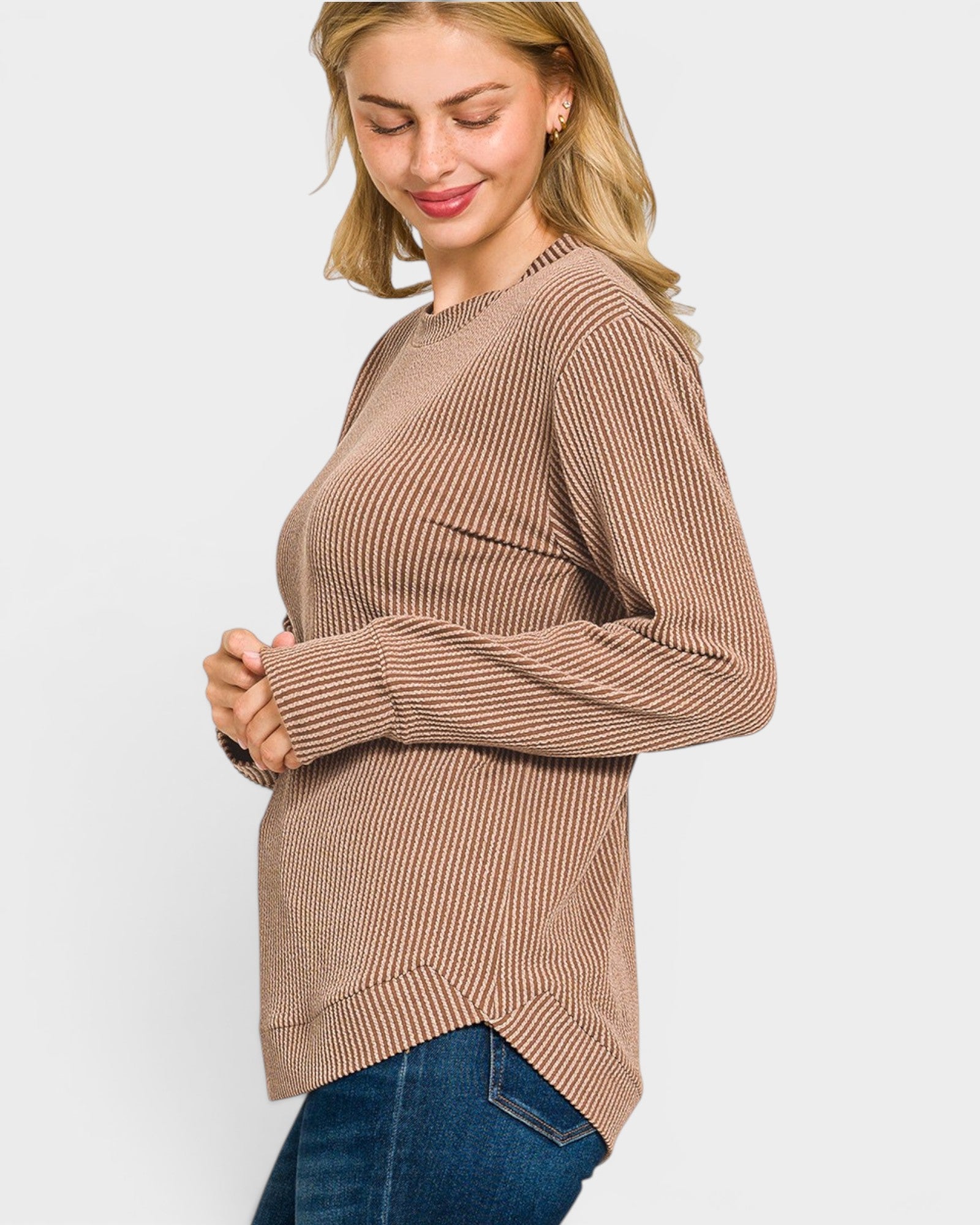 Woman wearing a brown ribbed sweater on a light gray background