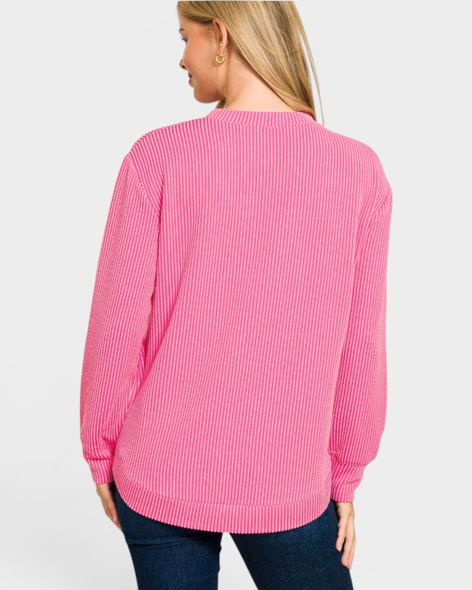 Person wearing a pink long-sleeve shirt on a light gray background