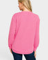 Person wearing a pink long-sleeve shirt on a light gray background